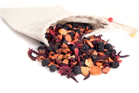 fruits and berries tea with hibiscus in linen bag over whiteの写真素材