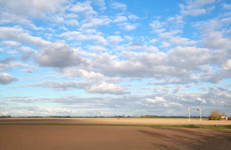 beautiful sky over plowed field in Dutch farmlandの写真素材