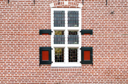 old red wooden window on brick wallの写真素材