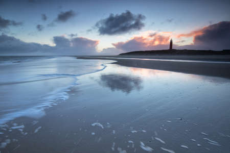 lighthouse on North sea coast in dusk, Netherlandsの写真素材