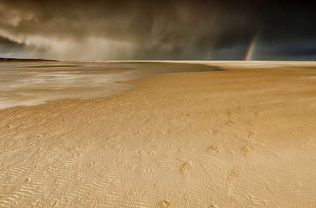 rainbow and dramatic sky over North sea coast, Netherlands