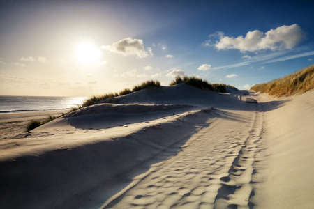 walking between sand dunes in sunshineの写真素材