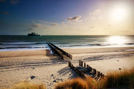sunshine over sand beach with view on ship