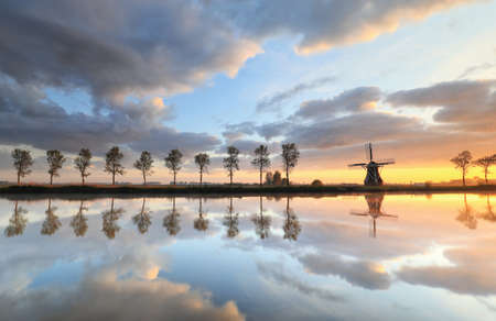beautiful sunrise over windmill and river on countryside, Hollandの写真素材