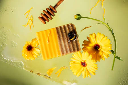 honey soap with calendula and bumble bee on yellowの写真素材