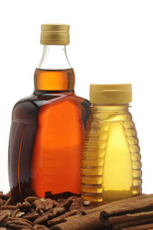 Bottle of maple syrup, honey, cinnamon and nuts の写真素材
