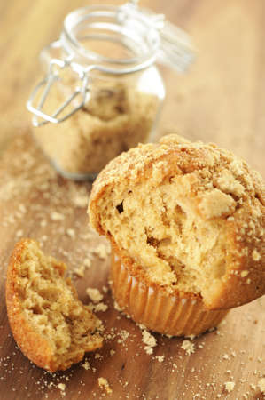 Brown sugar muffin with a bite on a wooden background.の写真素材