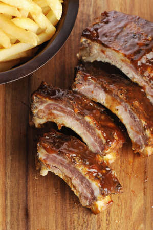Grilled sliced barbecue pork ribs on a wooden background の写真素材