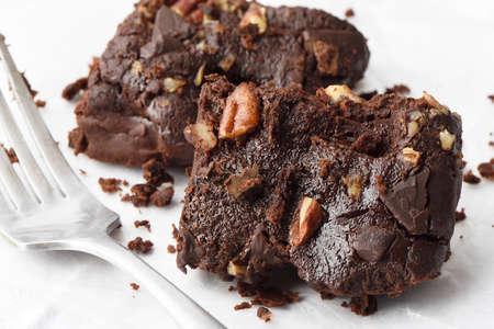 Homemade chocolate brownies with pecan nuts on a white backgroundの写真素材