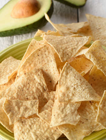 Green flat full of tortilla chips on a white background