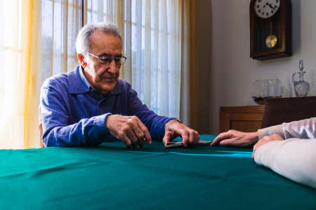 Grandparents playing a card game in home