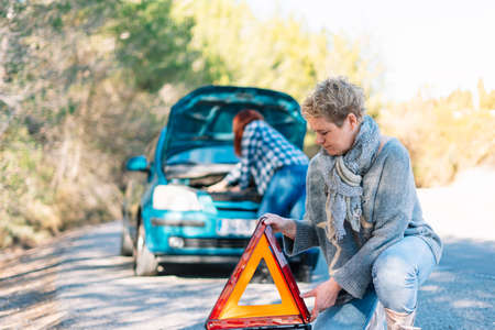 two women with a broken down car