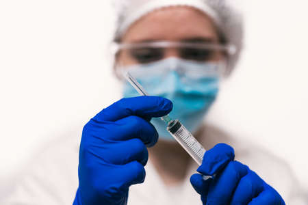 Doctor preparing a syringe for an injectionの写真素材