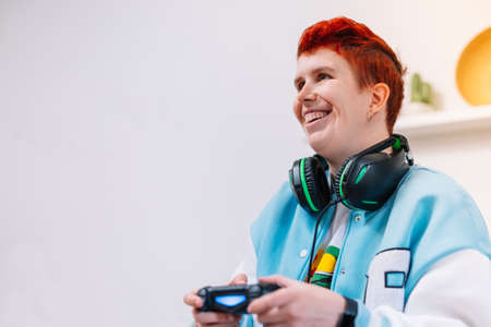 Young modern woman playing video games in the living room