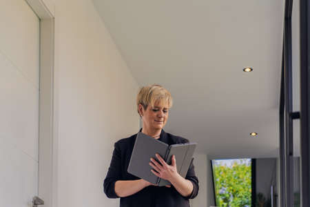 portrait of business woman checking email on her Tablet. owner in her small beauty salon looking at...