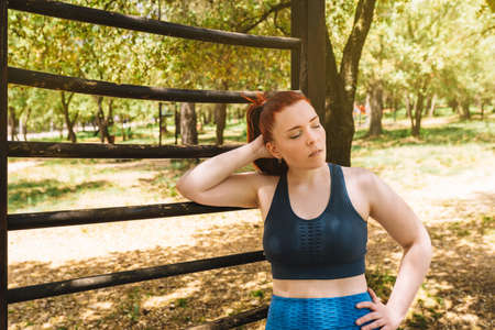 young woman athlete, resting after training on an outdoor trellis. athlete practising outdoor sport....