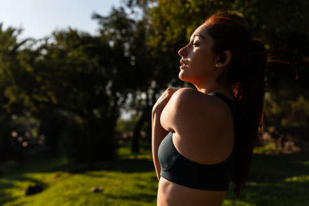 beautiful caucasian young woman doing sports and stretching outdoors in the parkの写真素材