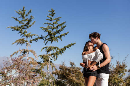 a beautiful young caucasian couple in love, playing, dancing and sharing nature outdoors on a sunny...