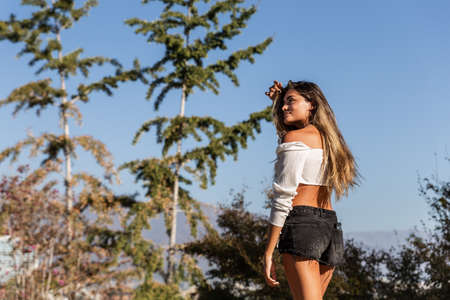 beautiful young blonde caucasian woman enjoying nature while walking and playing outdoors on a sunny...