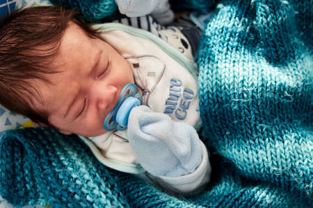 caucasian newborn baby lying on his blanket by the window getting sun in the middle of the covid19...