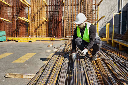 young man with mask and helmet in the middle of his job as a construction tool salesman, in the...