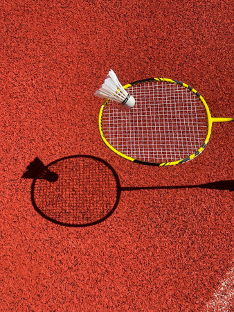 Racket and shuttlecock for badminton against the backdrop of a playground on a sunny dayの写真素材