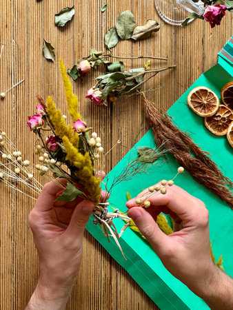 Florist at work. Men making a bouquet of dried flowersの写真素材