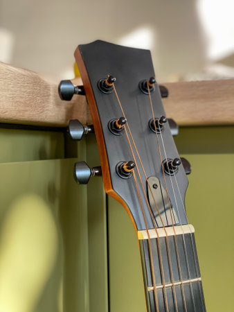 The neck of the guitar is black and the brown wooden side is close-upの写真素材