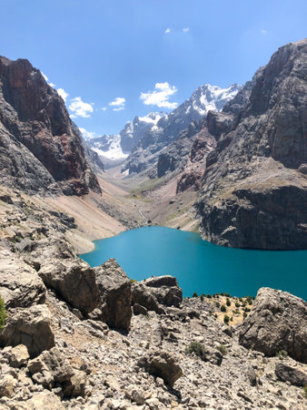 The lake is bright blue surrounded by rocky mountainsの写真素材