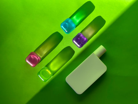 Cosmetic bottle and coloured transparent cubes. Sunlight and shadowsの写真素材