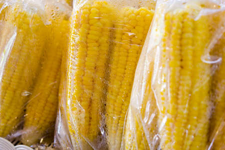 Steamed corn in a plastic bagの写真素材