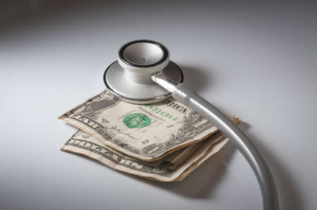 A stethoscope and American money on a white background - Healthcare cost conceptの写真素材