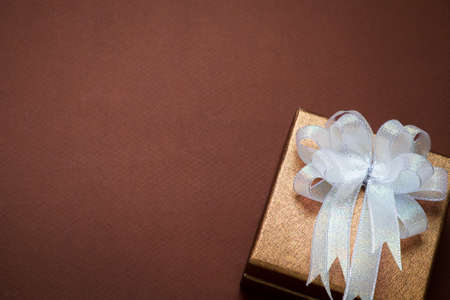 Luxury golden gift box on brown background