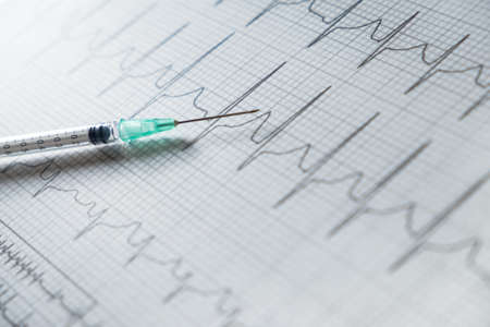 Syringe on EKG graph background