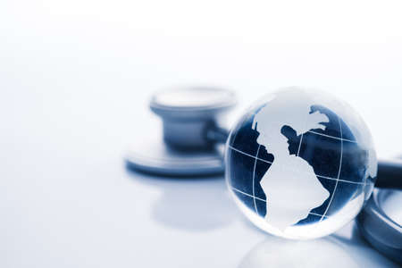 Global healthcare. Globe and stethoscope blue tone on white backgroundの写真素材