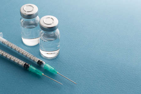 Syringes, medicine bottles on a blue background.