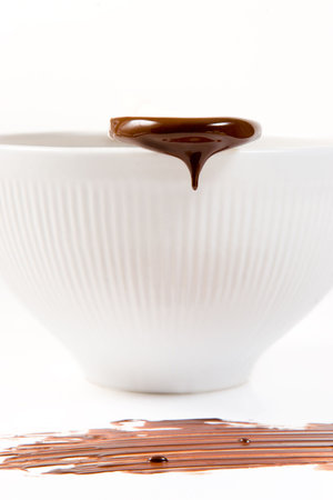 Melted dark chocolate dripping from the wooden spoonの写真素材