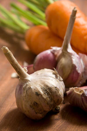 Fresh garlic and carrot on cutting boardの写真素材