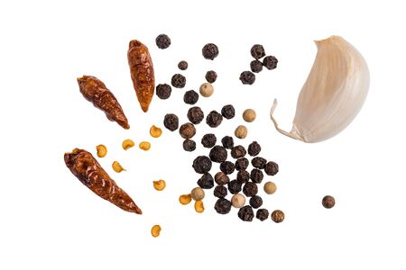 Dried chili peppers with black and white peppercorns and garlic isolated on a white background.