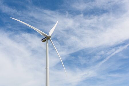 Close up of a wind turbine on a sunny day against a blue clouded sky and copy space.