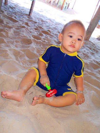 Cute little boy playing at the beach in summerの写真素材