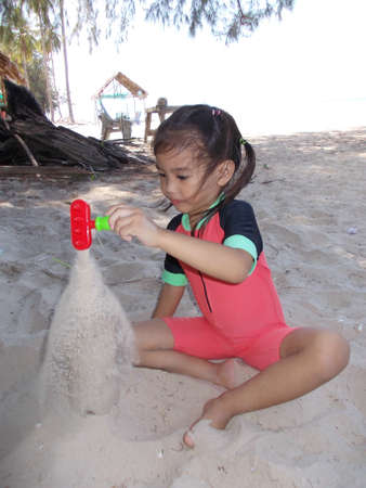Cute little girl playing at the beach in summerの写真素材