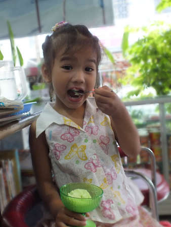 Little girl eating ice cream の写真素材