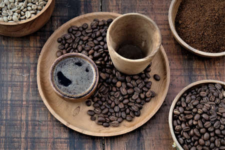 Brewed black Robusta and Arabica coffee powder, roasted coffee beans and raw coffee beans.の写真素材