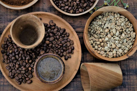 Brewed black Robusta and Arabica coffee powder, roasted coffee beans and raw coffee beans.の写真素材