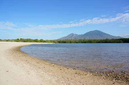 Beach with clean white sand, beautiful beach with the background of the high seas and mountainsの写真素材