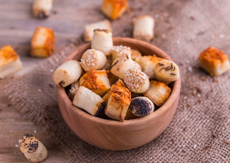 Salty party snacks in wooden bowl on natural background.の写真素材