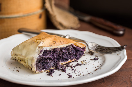 Poppy seeds strudel on white plate with fork on rustic background.の写真素材
