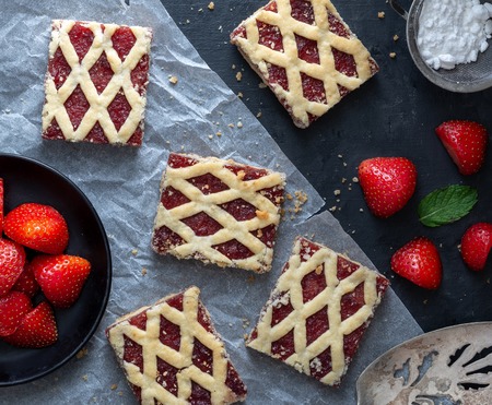 Strawberry cakes with strawberry fruits on dark background.