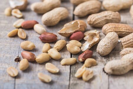 Peanuts scattered on natural wooden desk.